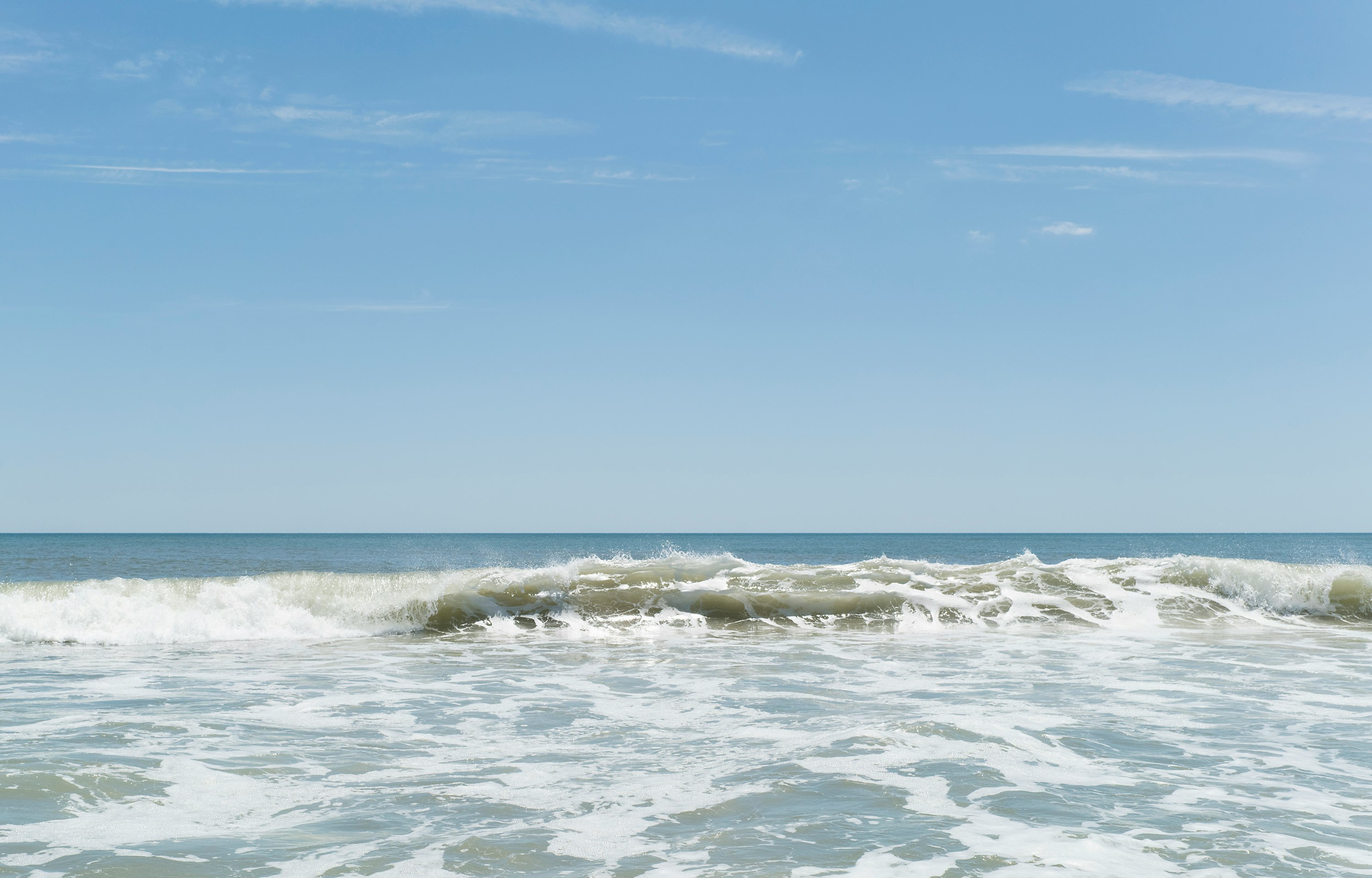 ocean waves under blue sky during daytime